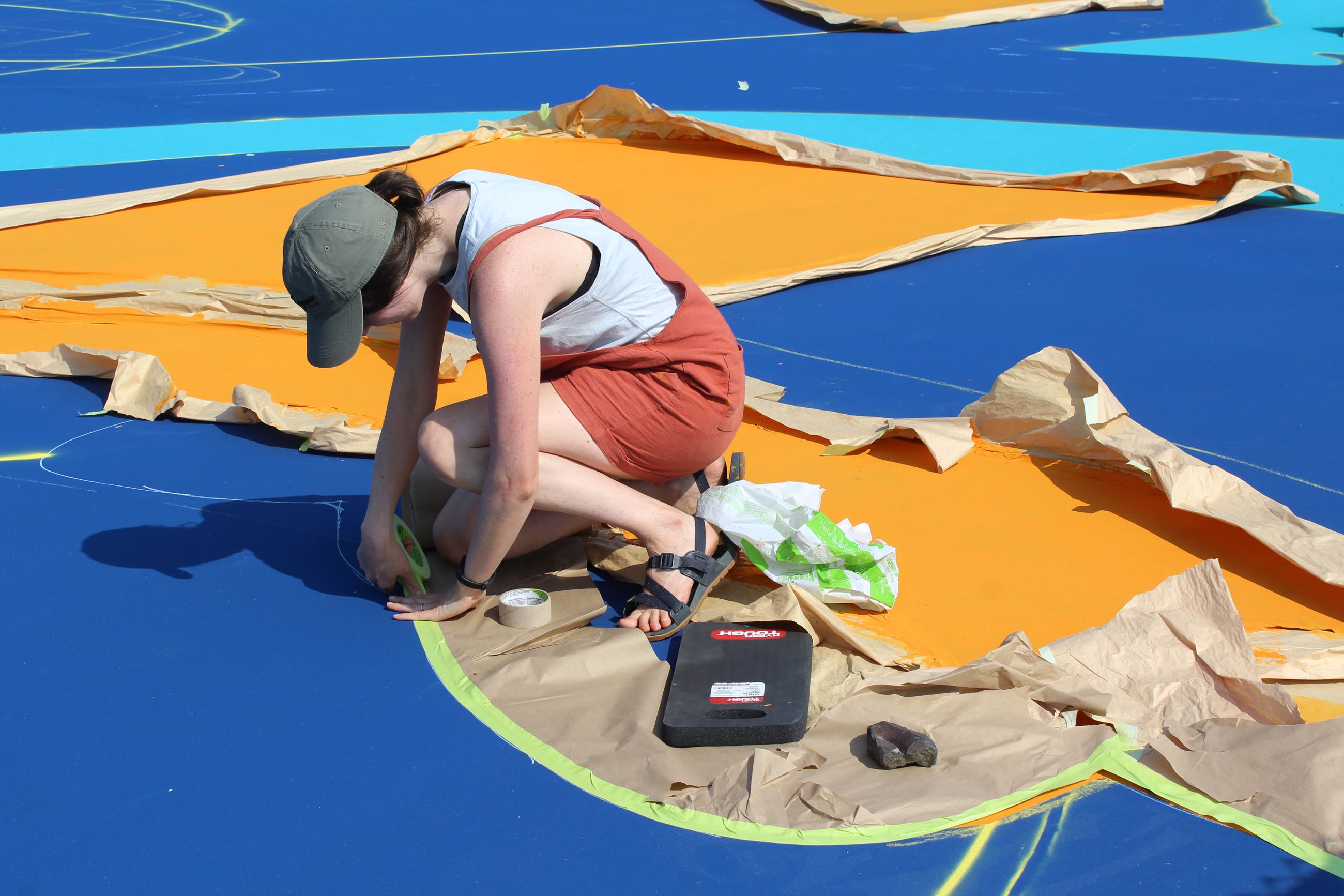 Image of artist painting Pavillion Basketball Court Mural