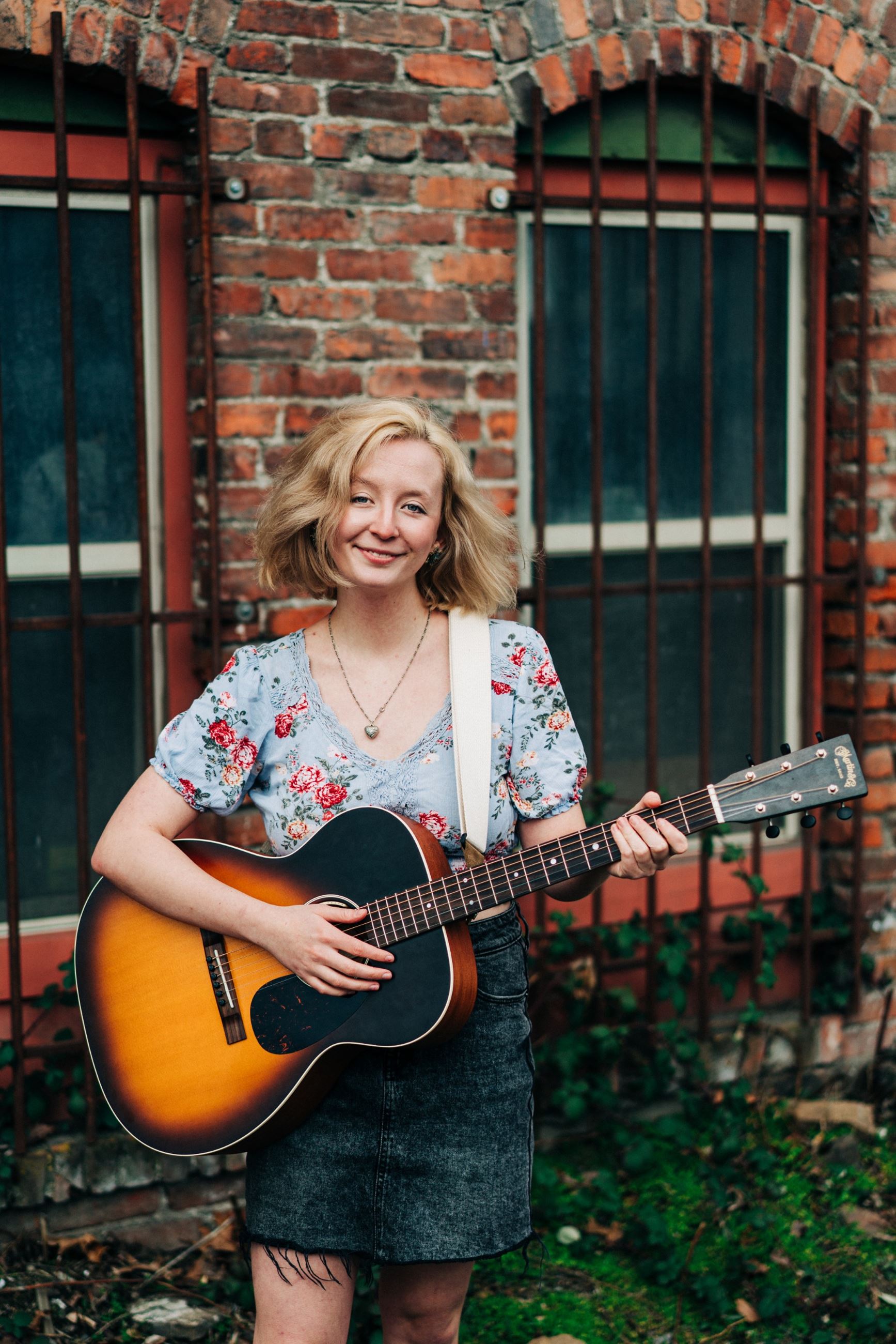 Image of Rachel Brodhead holding a guitar.